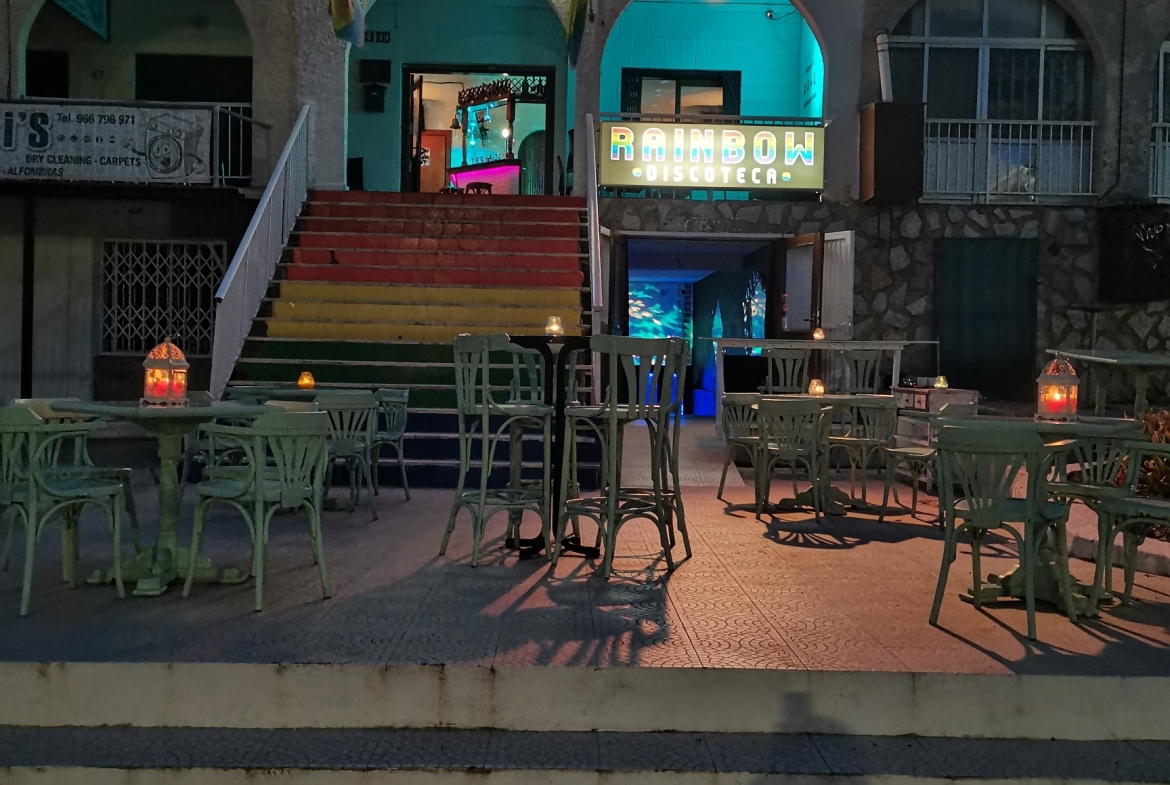 Night scene of illuminated entrance and steps to Rainbow Disco Bar La Marina